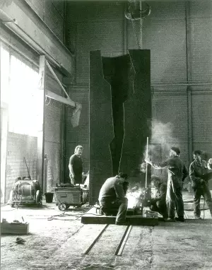 Oscar Wiggli travaille à la sculpture ESUM pour l'Université Miséricorde de Fribourg dans les ateliers de l'usine sidérurgique Von Roll, 1990.